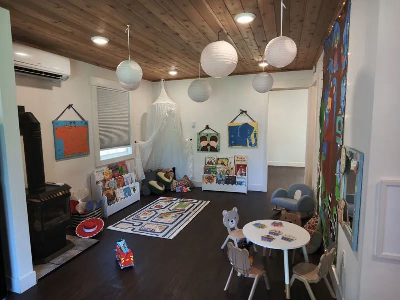The bright classroom with paper lanterns, a reading canopy and children&rsquo;s art on the walls