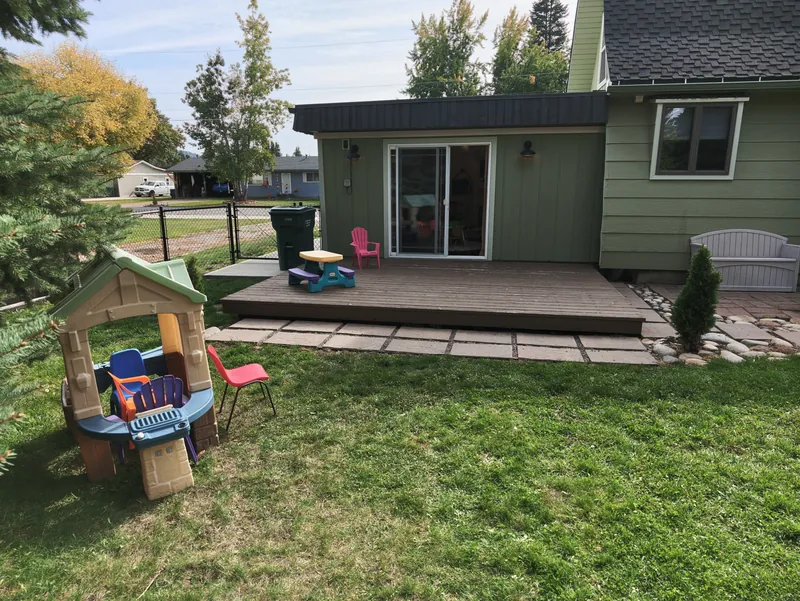 The back deck and yard, with the playhouse and open grass